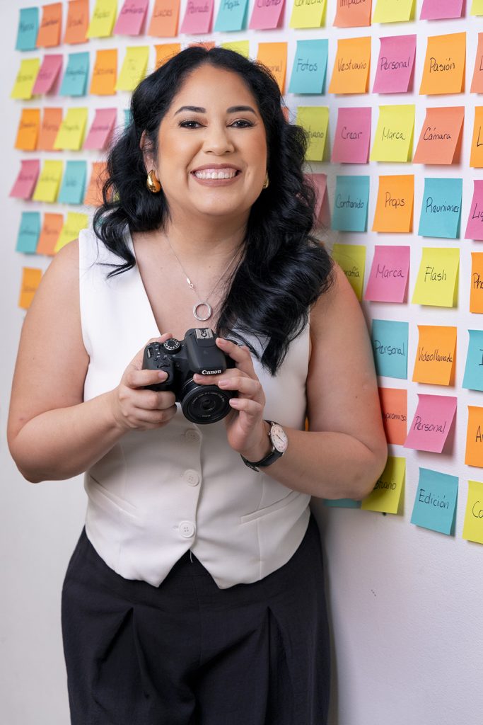 Fotógrafa de marca personal en Panamá sosteniendo cámara y sonriendo